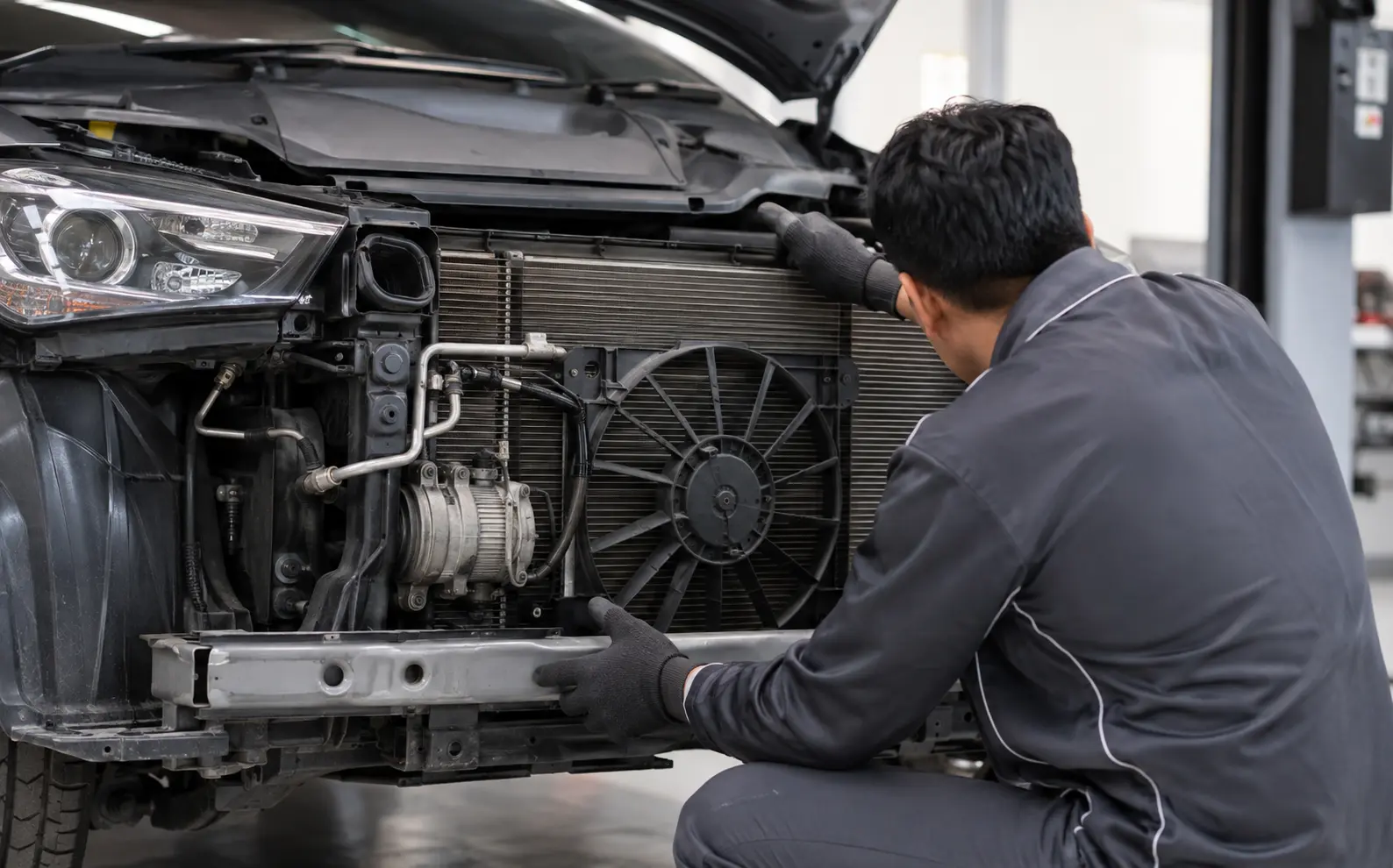 Technician inspecting car AC components in a Dubai workshop