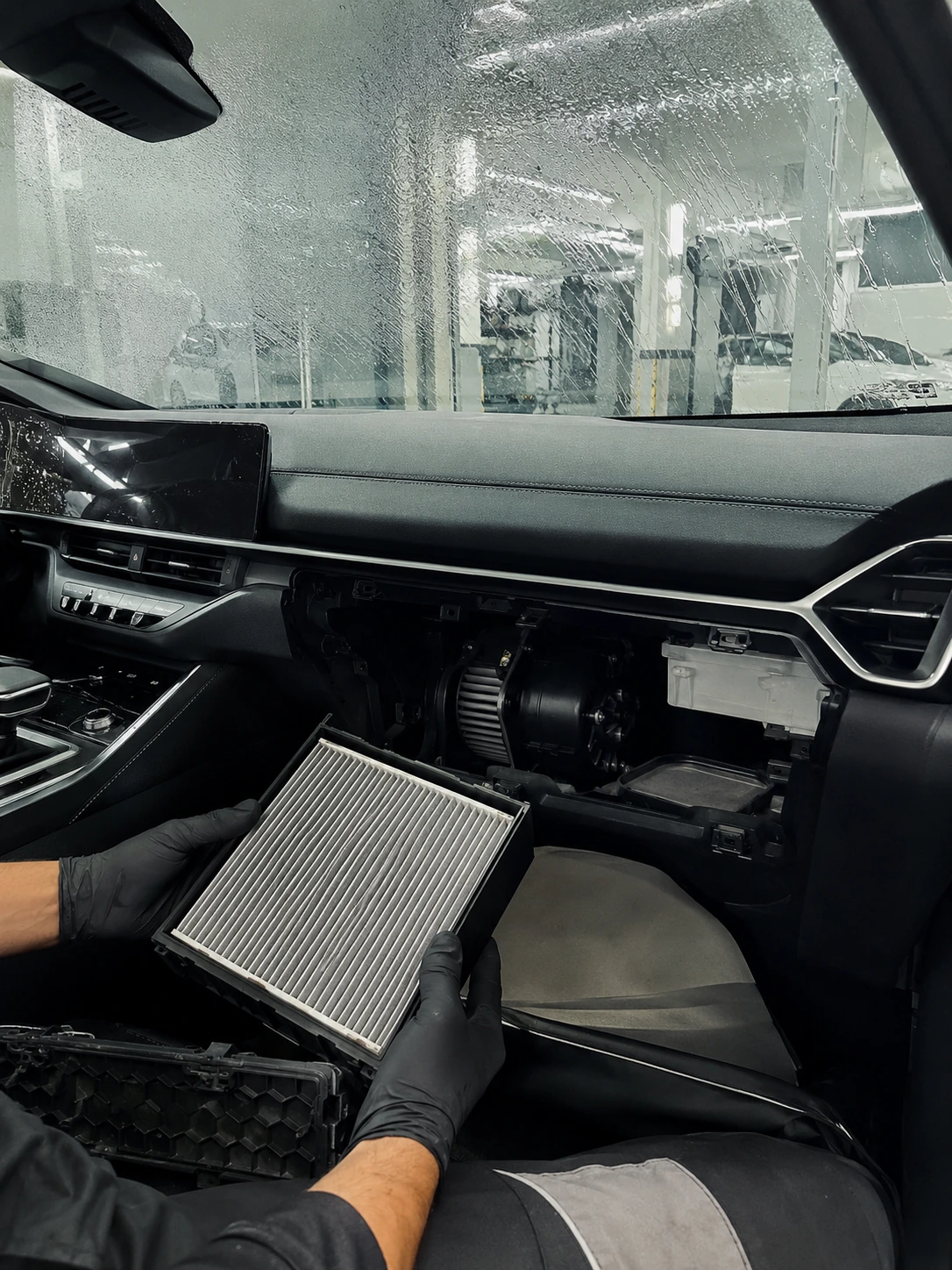 Technician checking windshield demist airflow and cabin humidity inside a modern car
